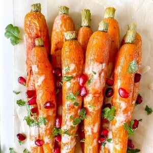 roasted carrots with tahini sauce, pomegranate and herbs.