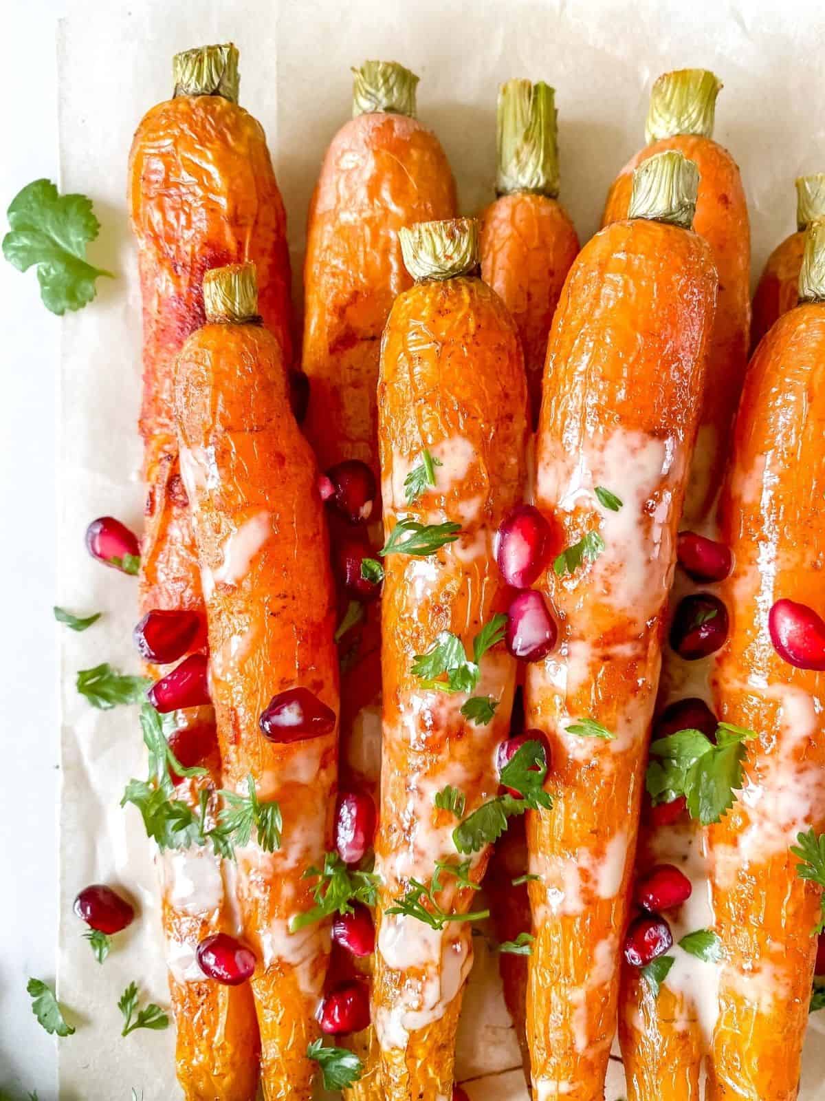roasted carrots with tahini sauce, pomegranate and herbs.