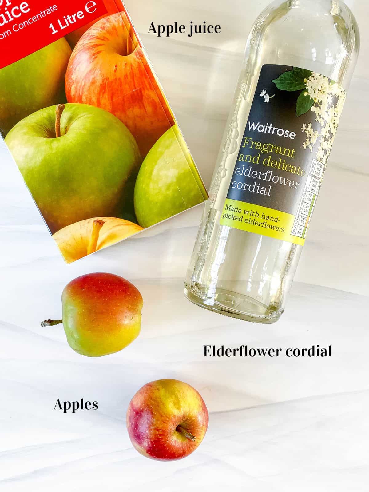 carton of apple juice, elderflower cordial and apples.