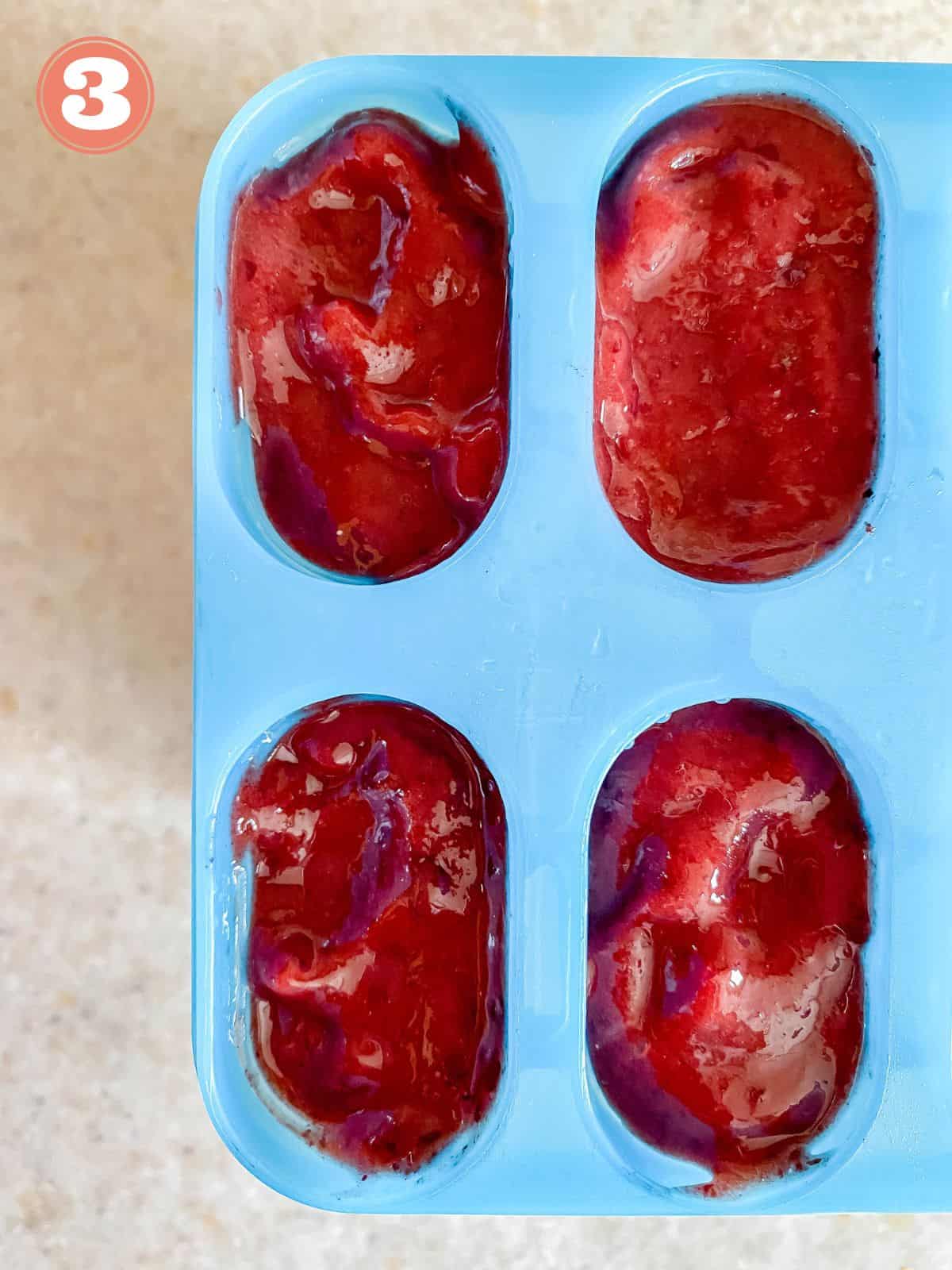 cherry popsicles in a blue mold.