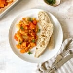 sweet potato corn on a white plate with two slices of bread next to a dish of hash.