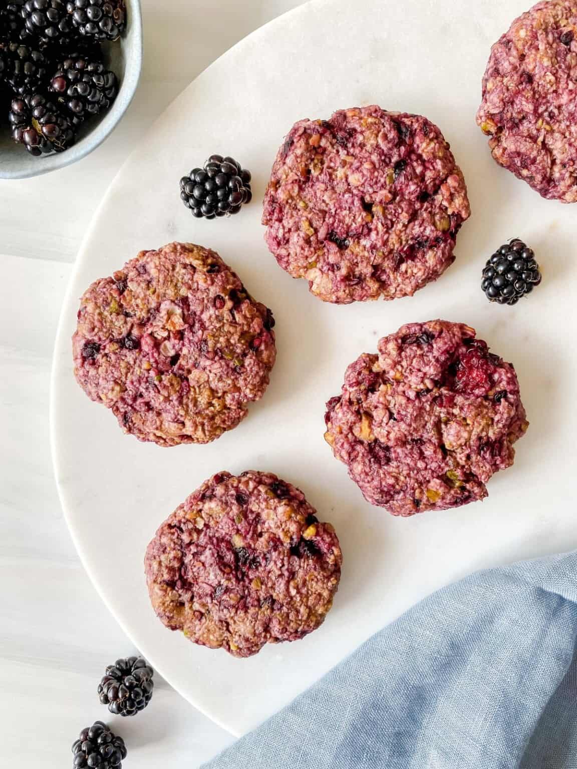 Blackberries and blackberry oatmeal cookies on a plate.