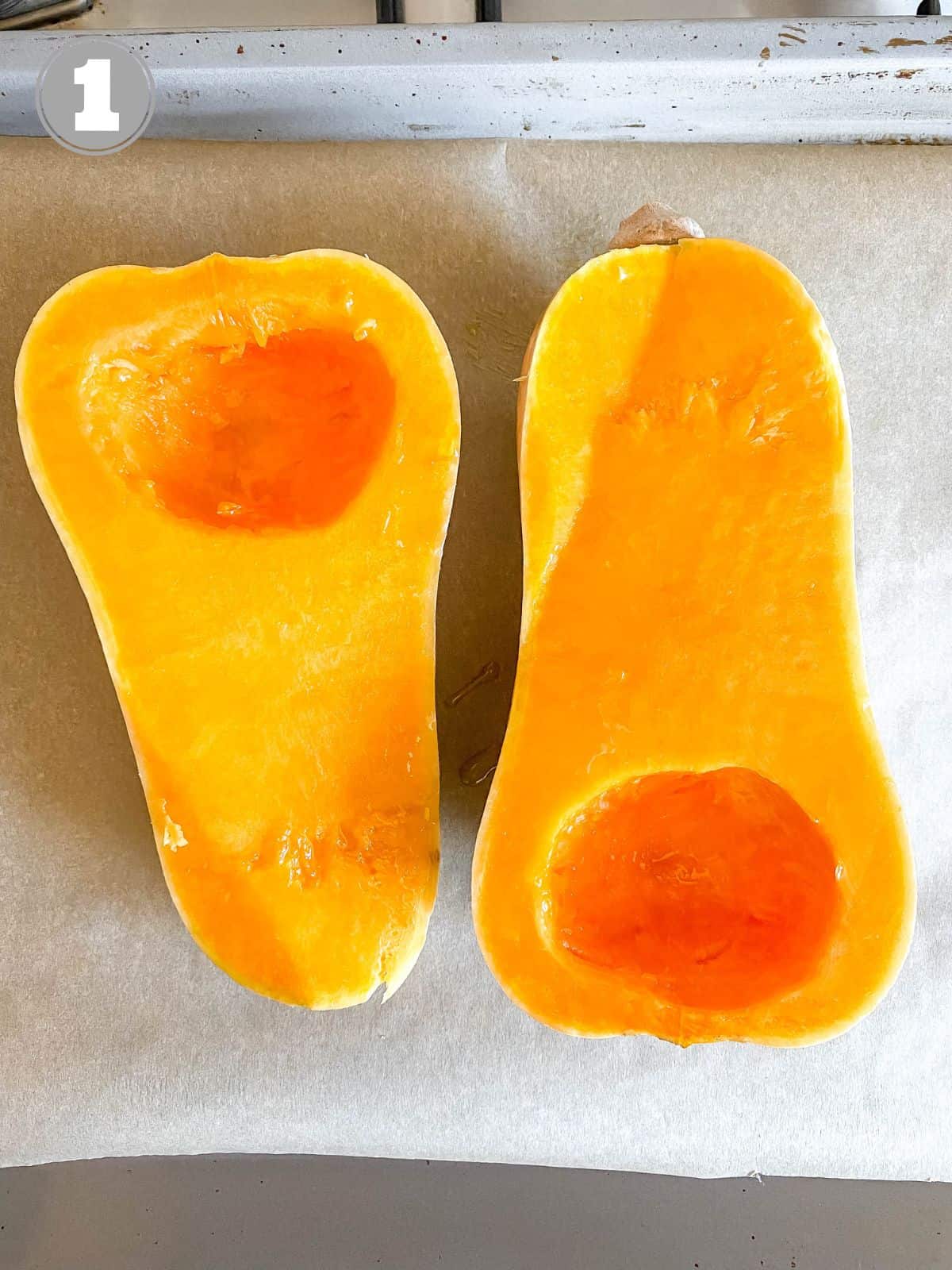 butternut squash halves on a lined baking tray.