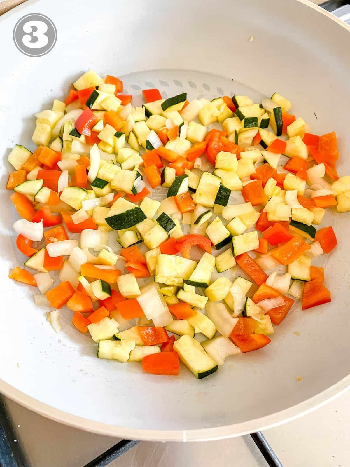 diced vegetables in a light grey skillet.