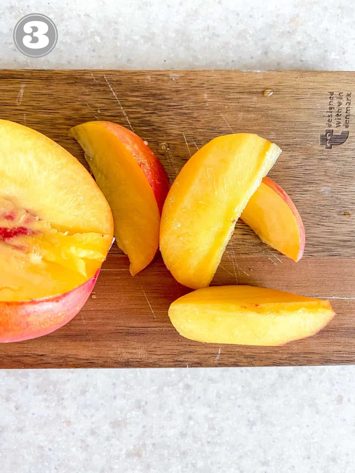 sliced peaches on a wooden board labelled number three.