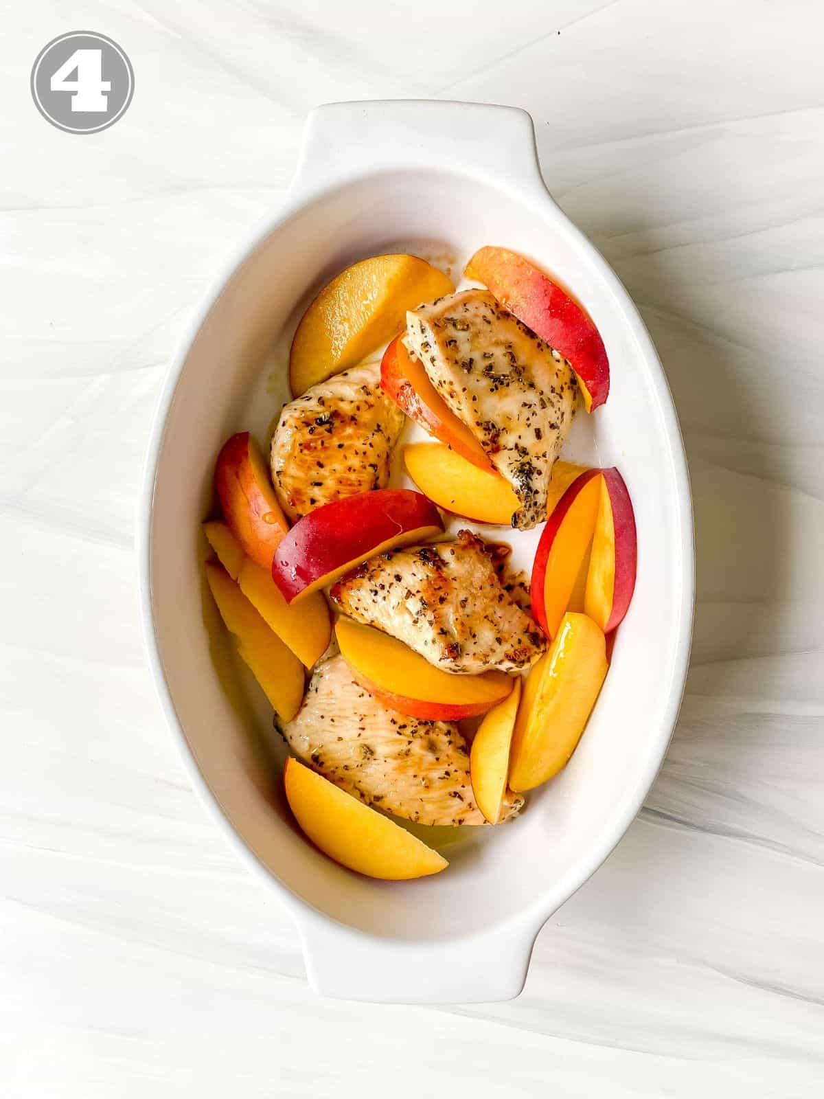 chicken and nectarines in a white ovenproof dish.