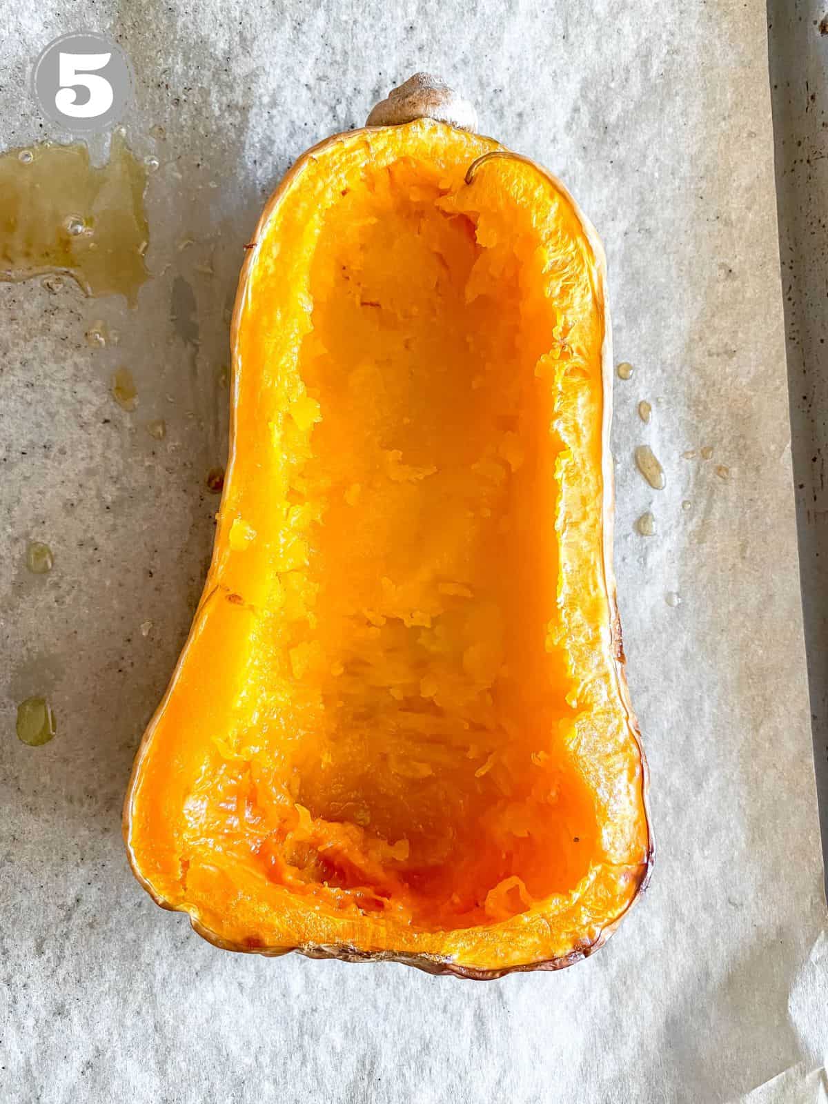 scooped out butternut squash on a lined baking tray.