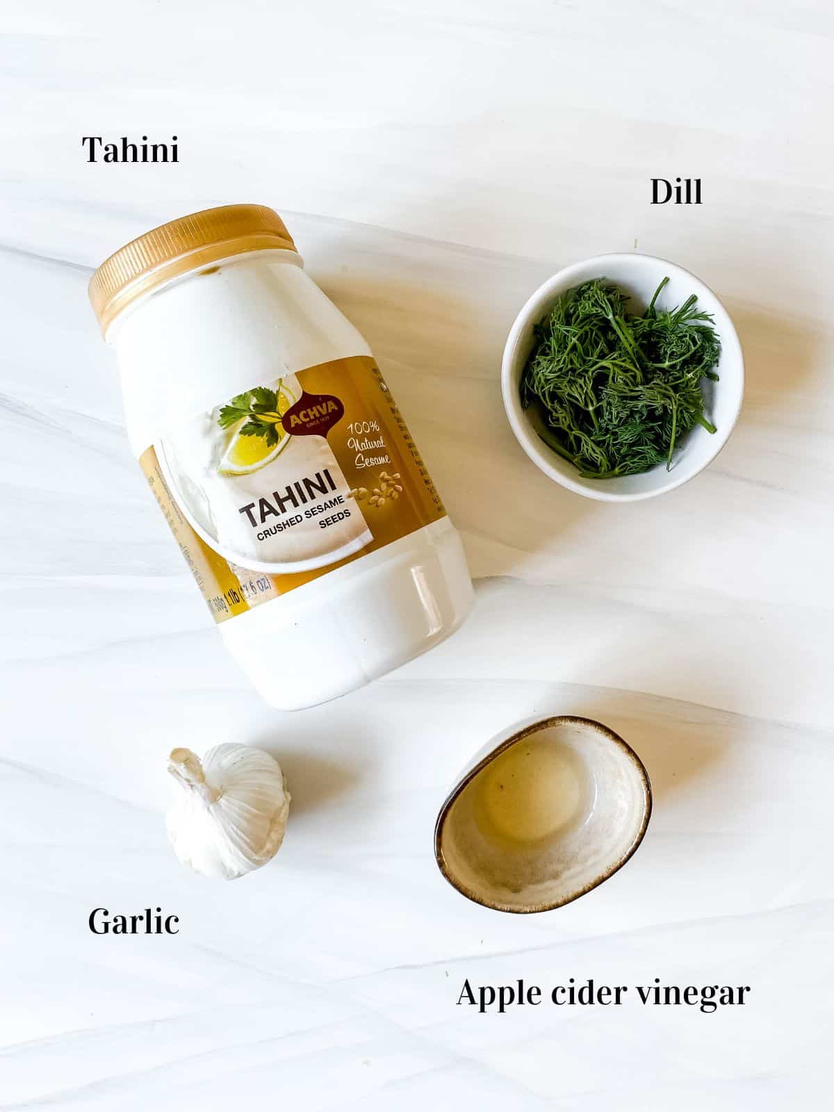 individually labelled ingredients of tahini, dill, apple cider vinegar and garlic.
