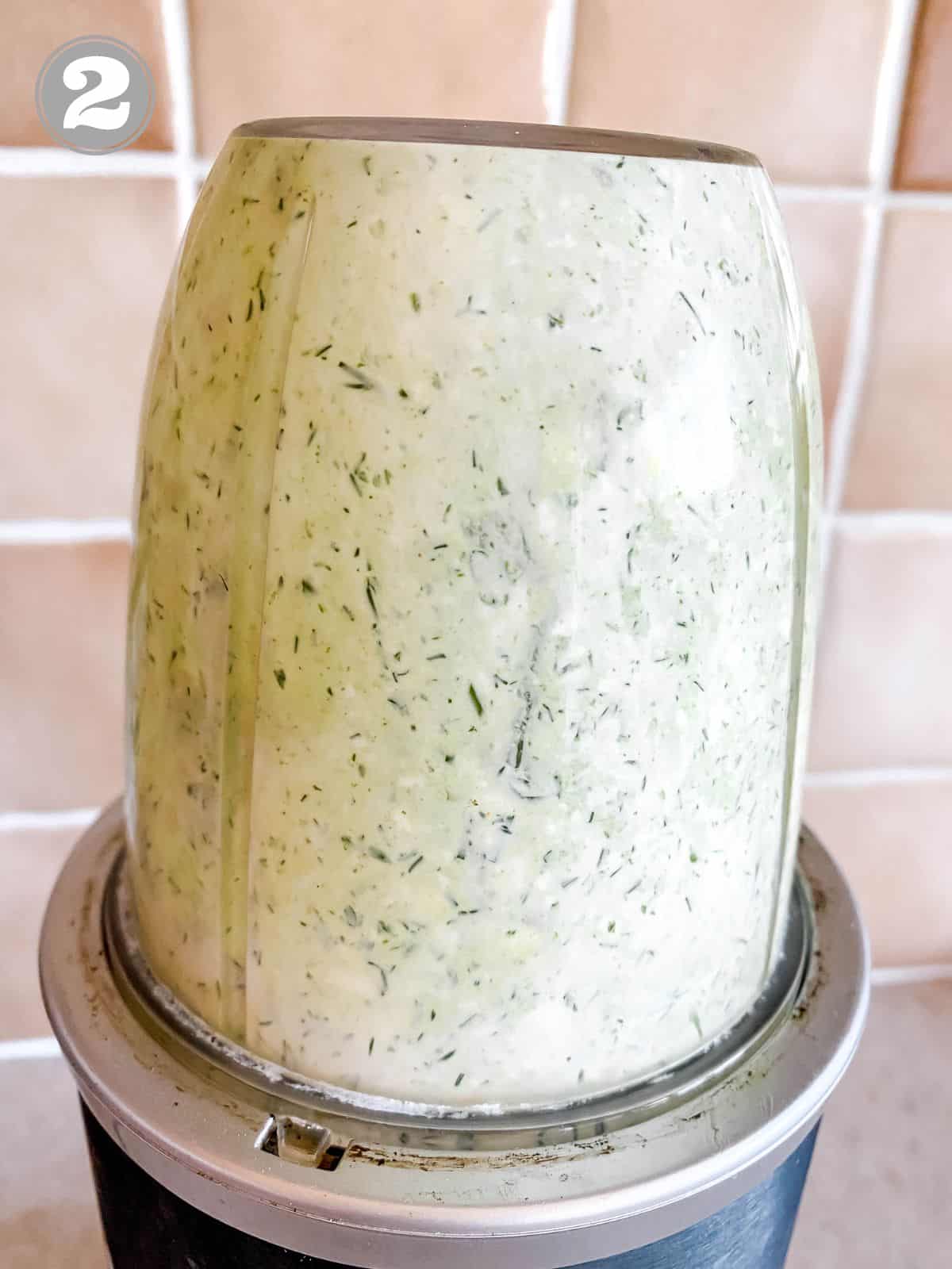 cottage cheese dill dip in a blender in front of a light brown tiled wall.
