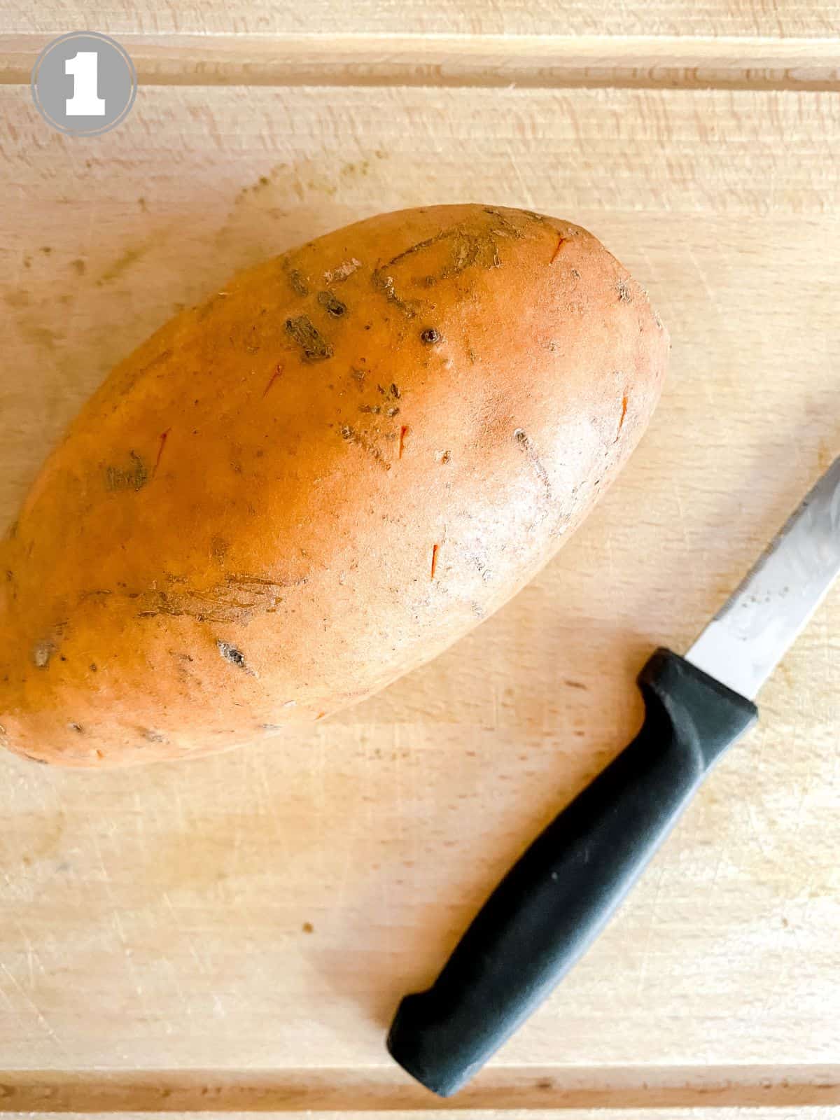 sweet potato and knife on a wooden chopping board labelled number one.
