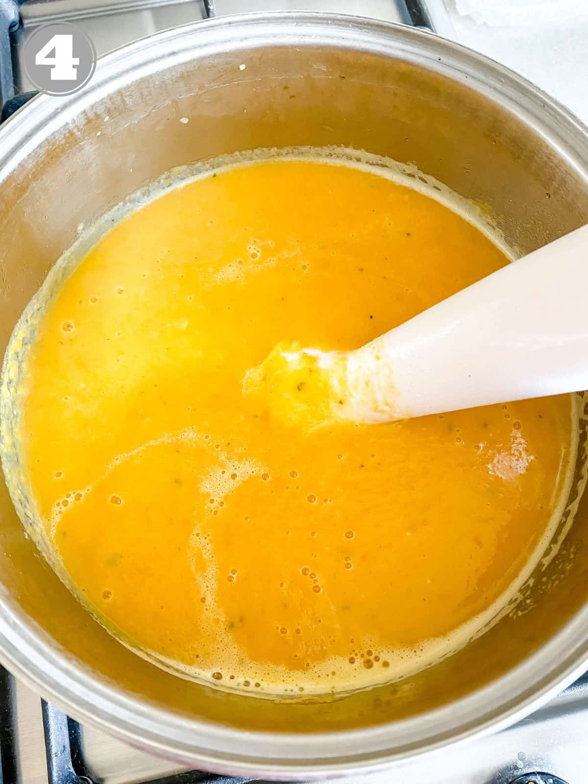 soup being blended by an immersion blender labelled number four.