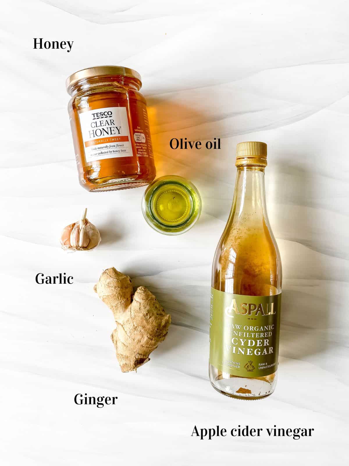 individually labelled ingredients to make honey ginger salad dressing including honey, garlic and apple cider vinegar.