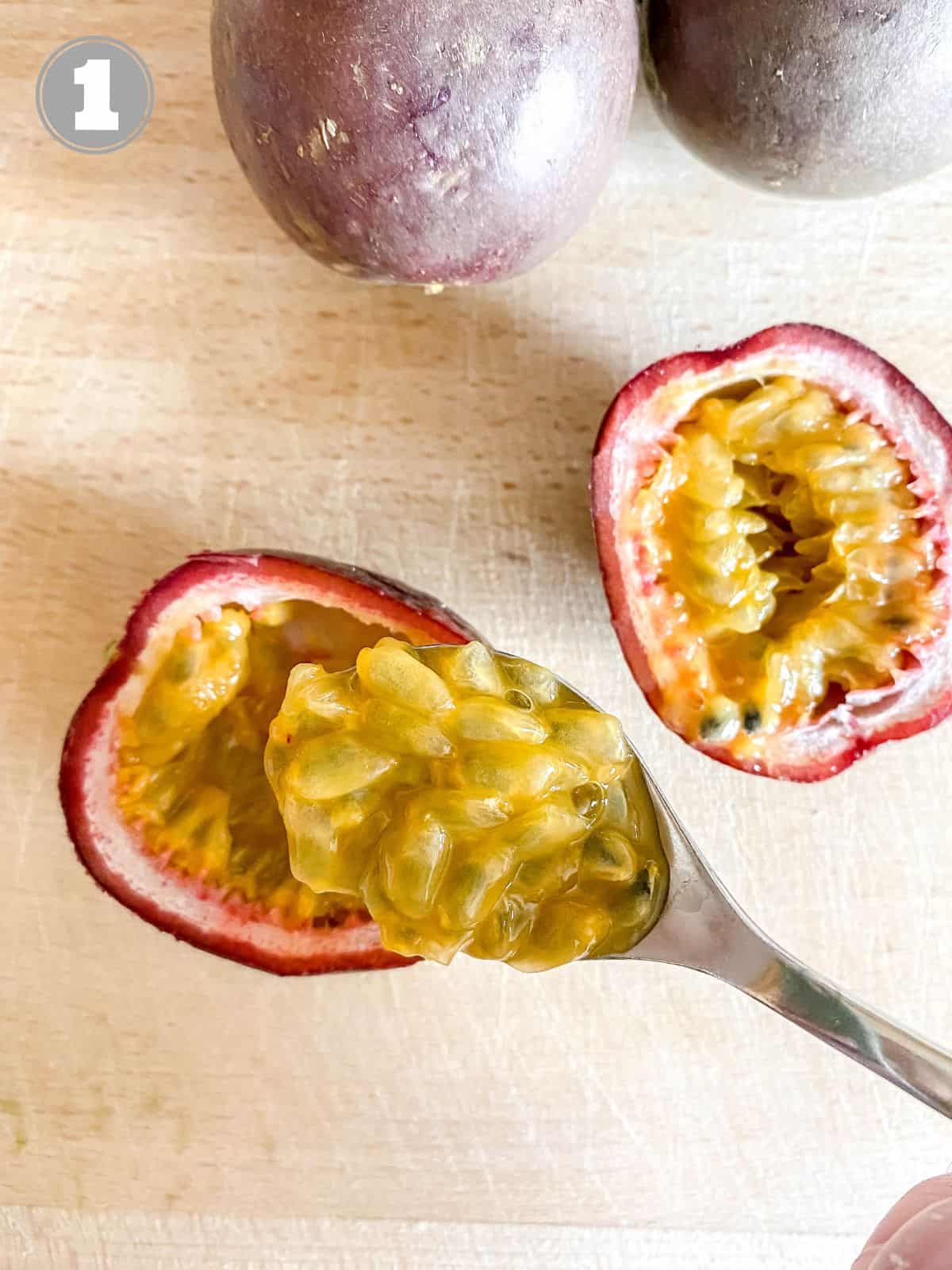 passion fruits on a wooden board with a spoonful of seeds labelled number one.