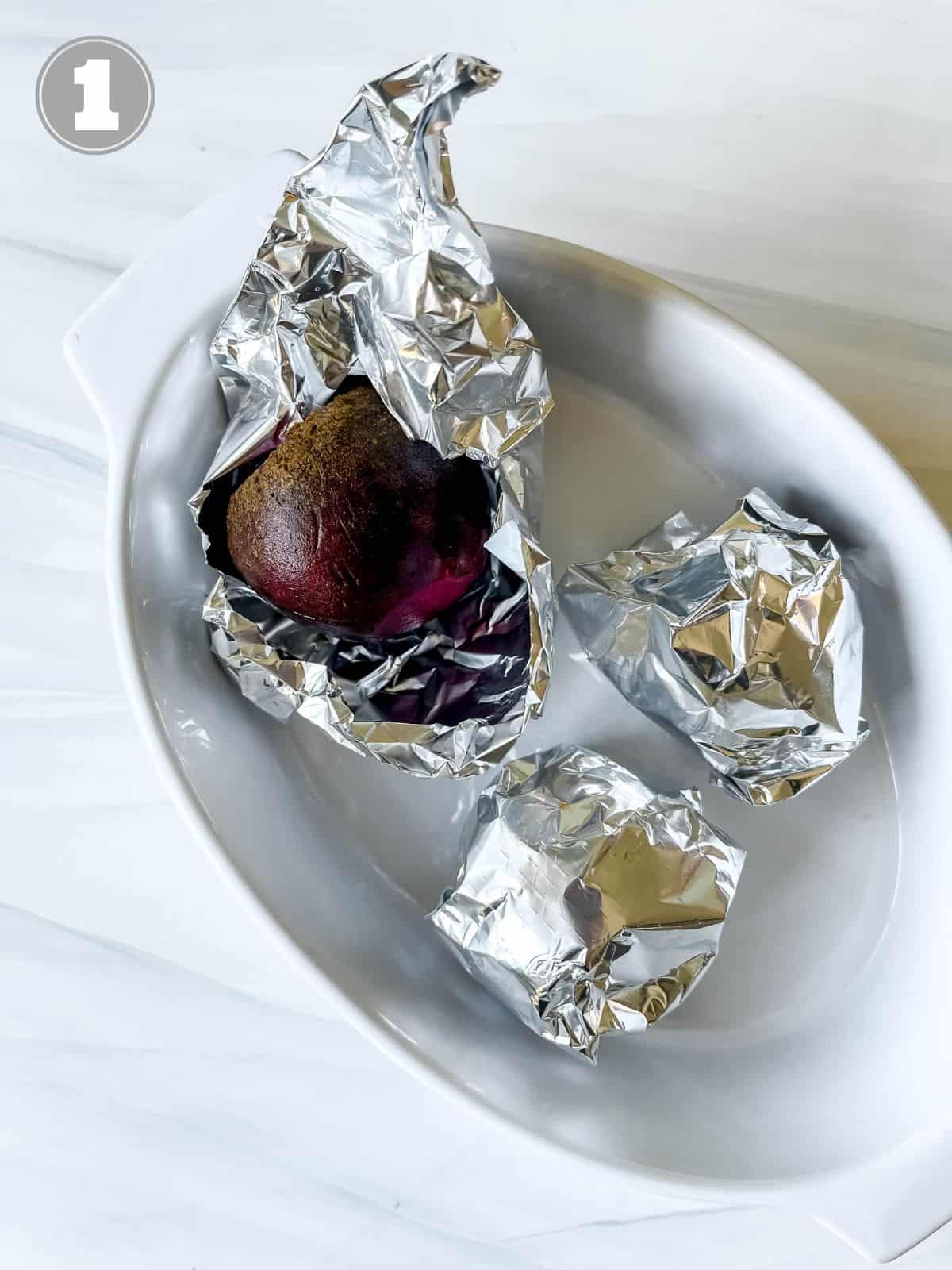 beets wrapped in foil in a white baking dish labelled number one.