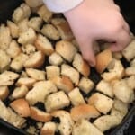 croutons with a person picking a crouton up.