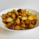 garlic roast potatoes in a white bowl.