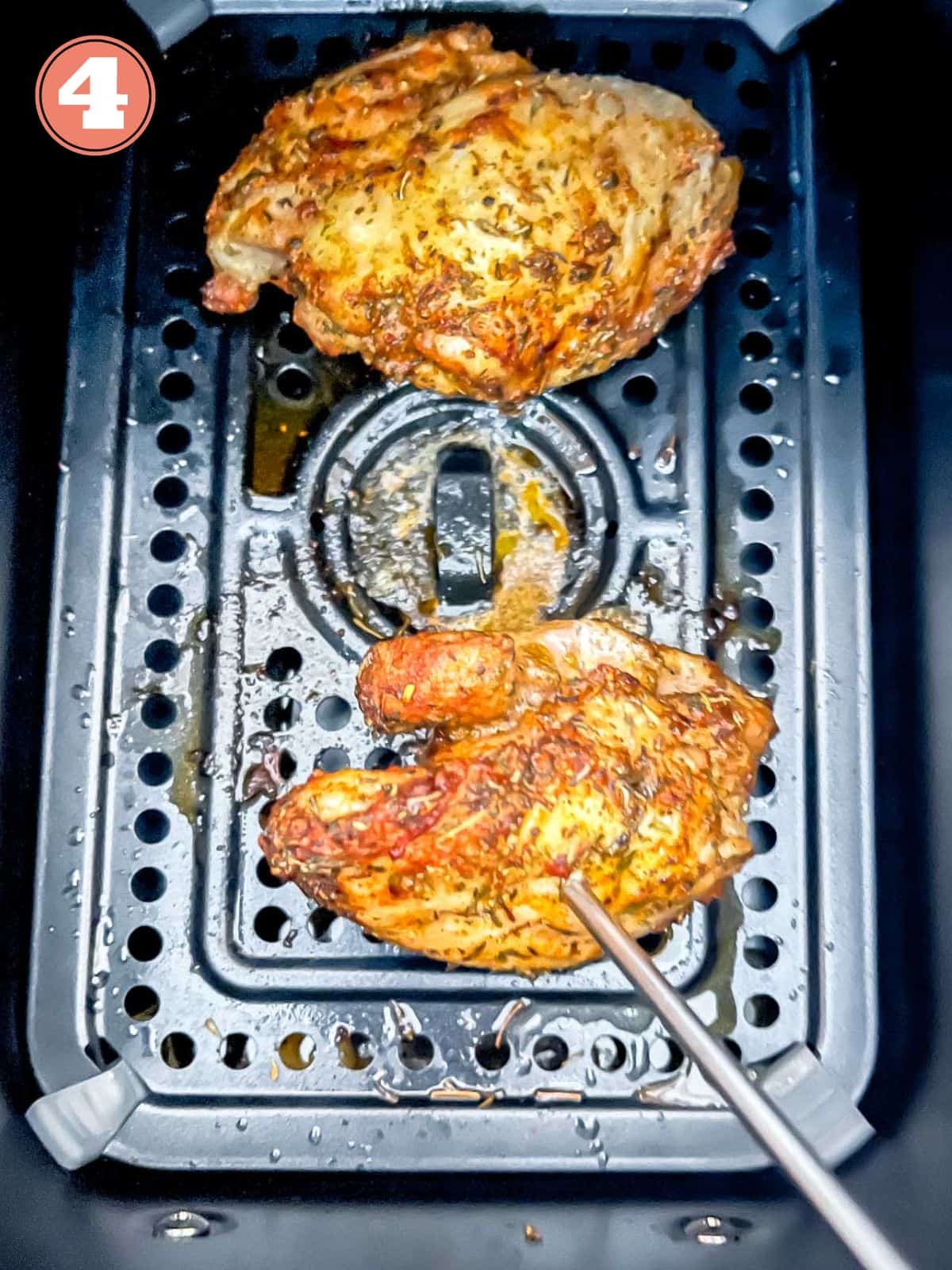 chicken thighs with a temperature probe in them in an air fryer basket labelled number four.