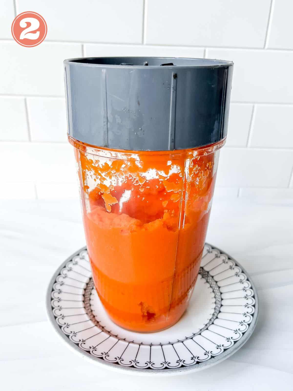carrot juice in a blender on a plate labelled number two.
