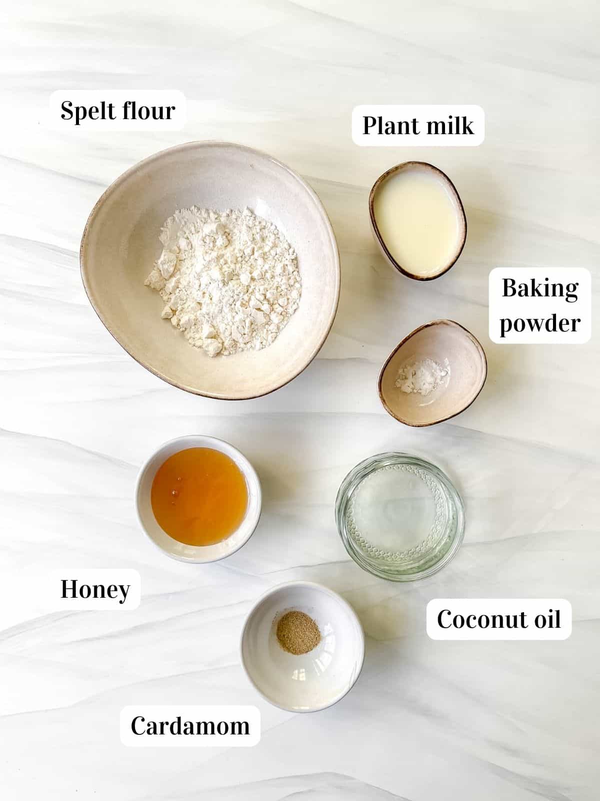 individually labelled ingredients to make honey mug cake including baking powder, cardamom and spelt flour.
