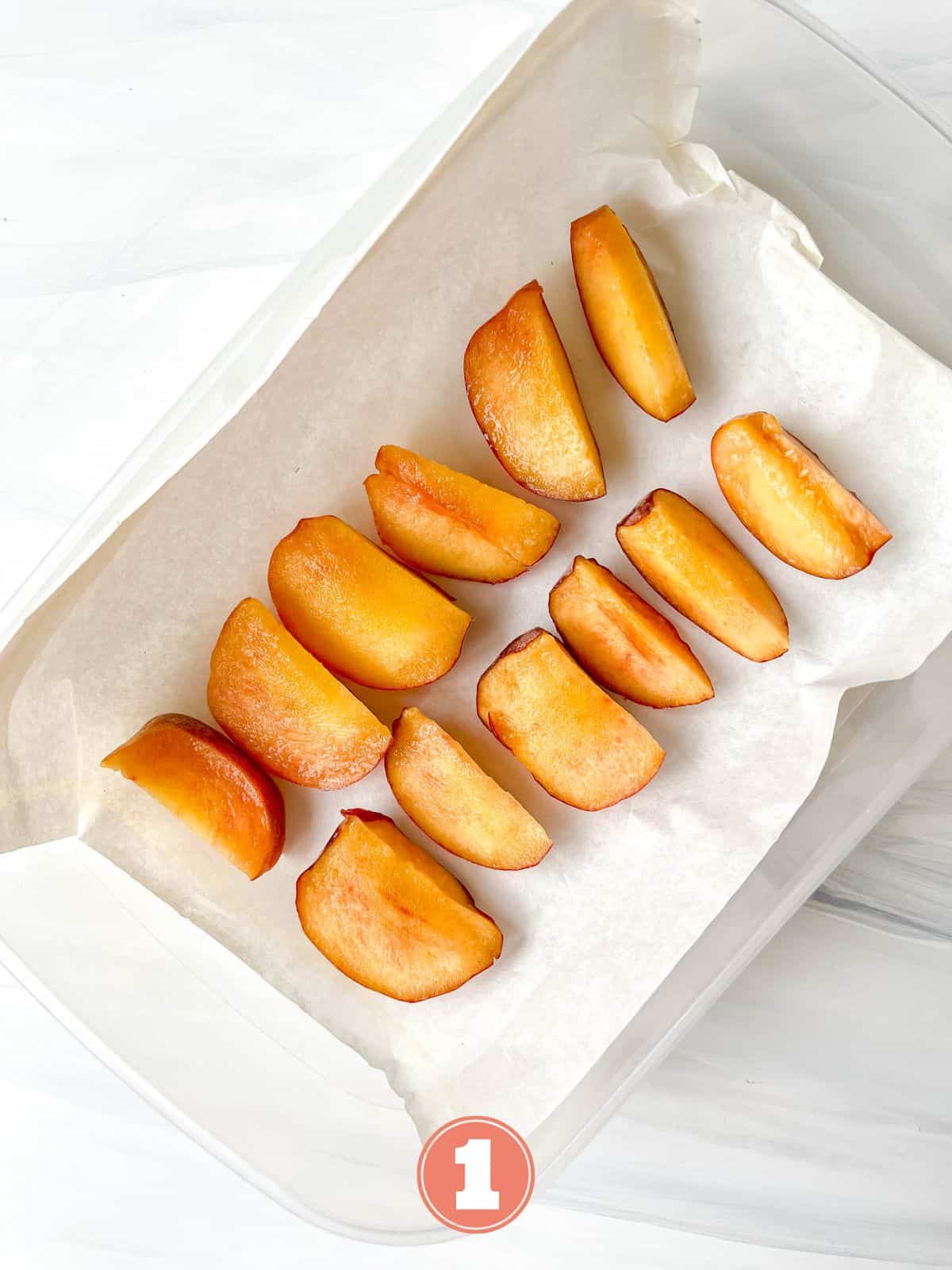 slices of peach in a tupperware container lined with parchment paper labelled number one.