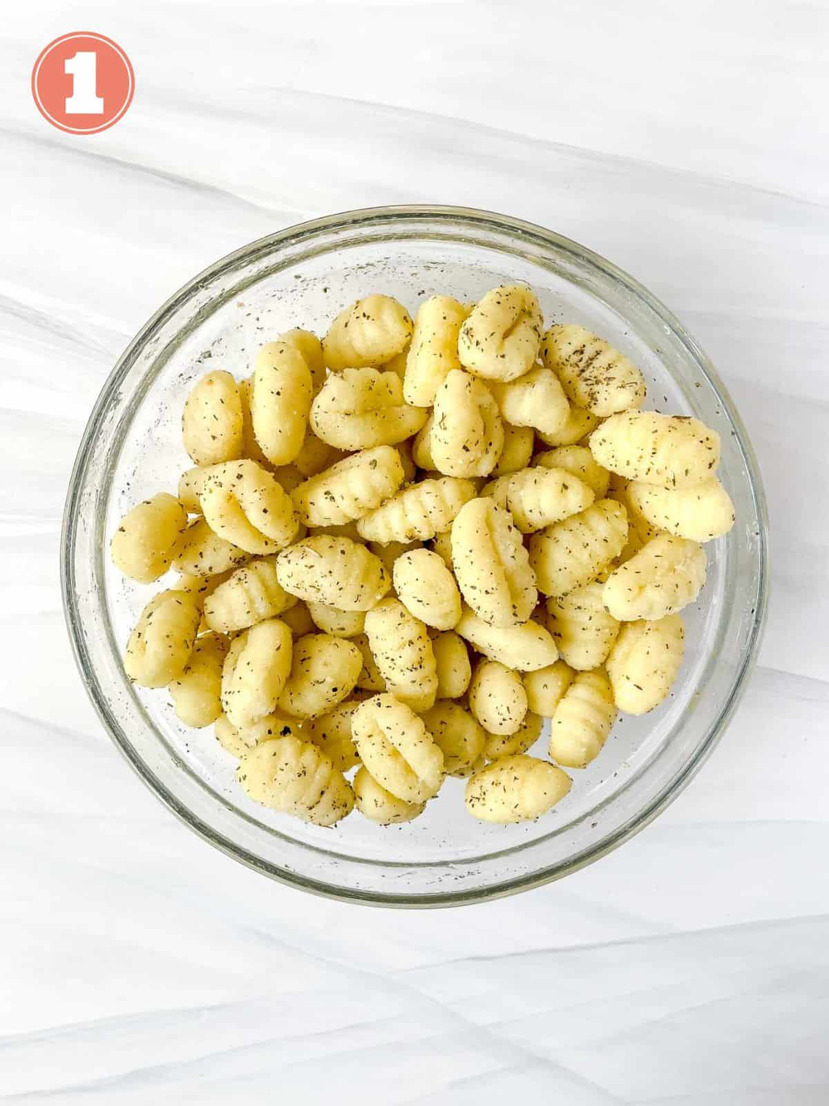 gnocchi coated in herbs in a glass bowl labelled number one.