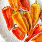 red and yellow mini peppers on a light grey mottled plate.