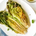 romaine lettuce halves on a white plate on a blue cloth.