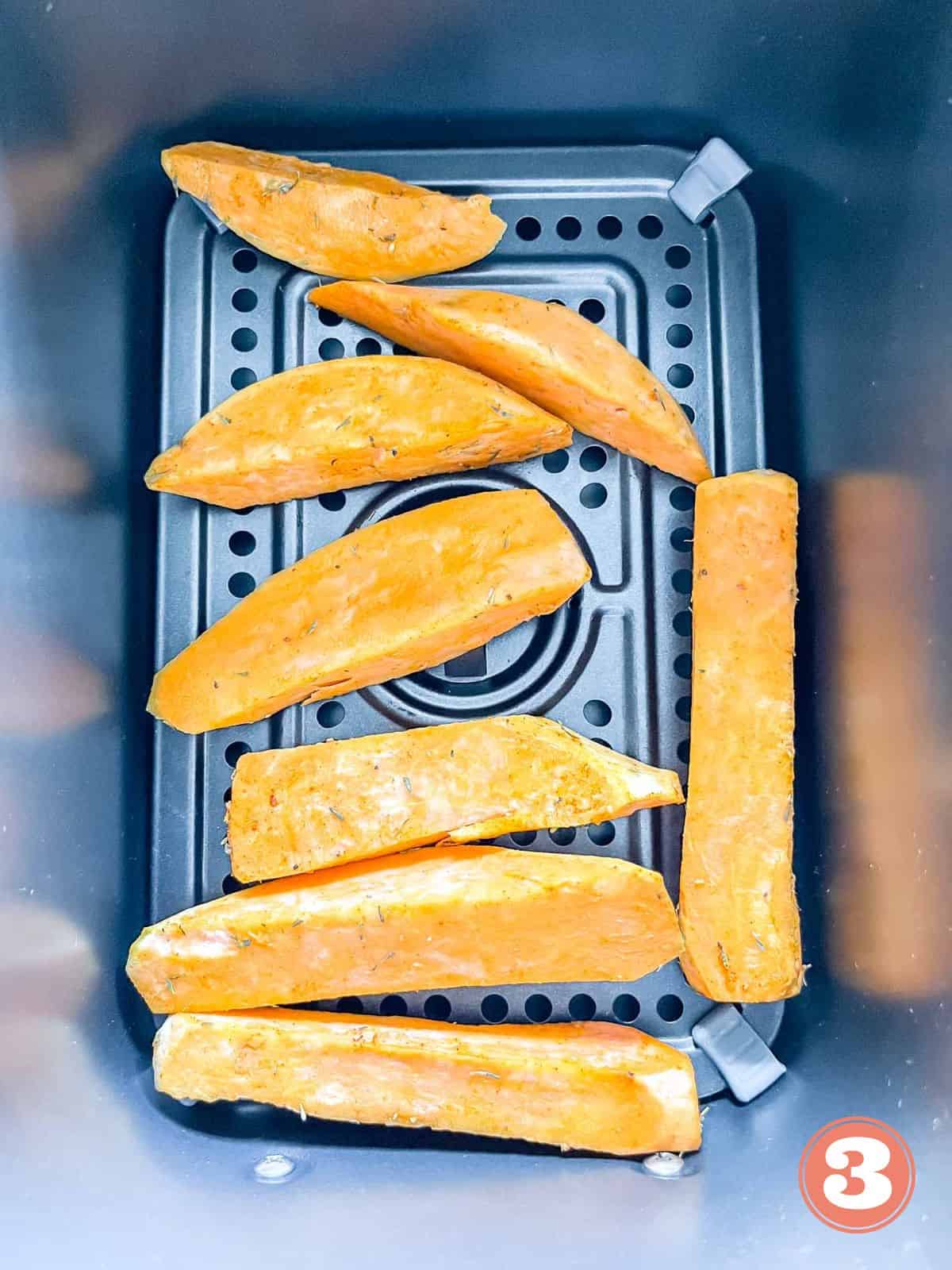 sweet potato wedges in an air fryer basket labelled number three.
