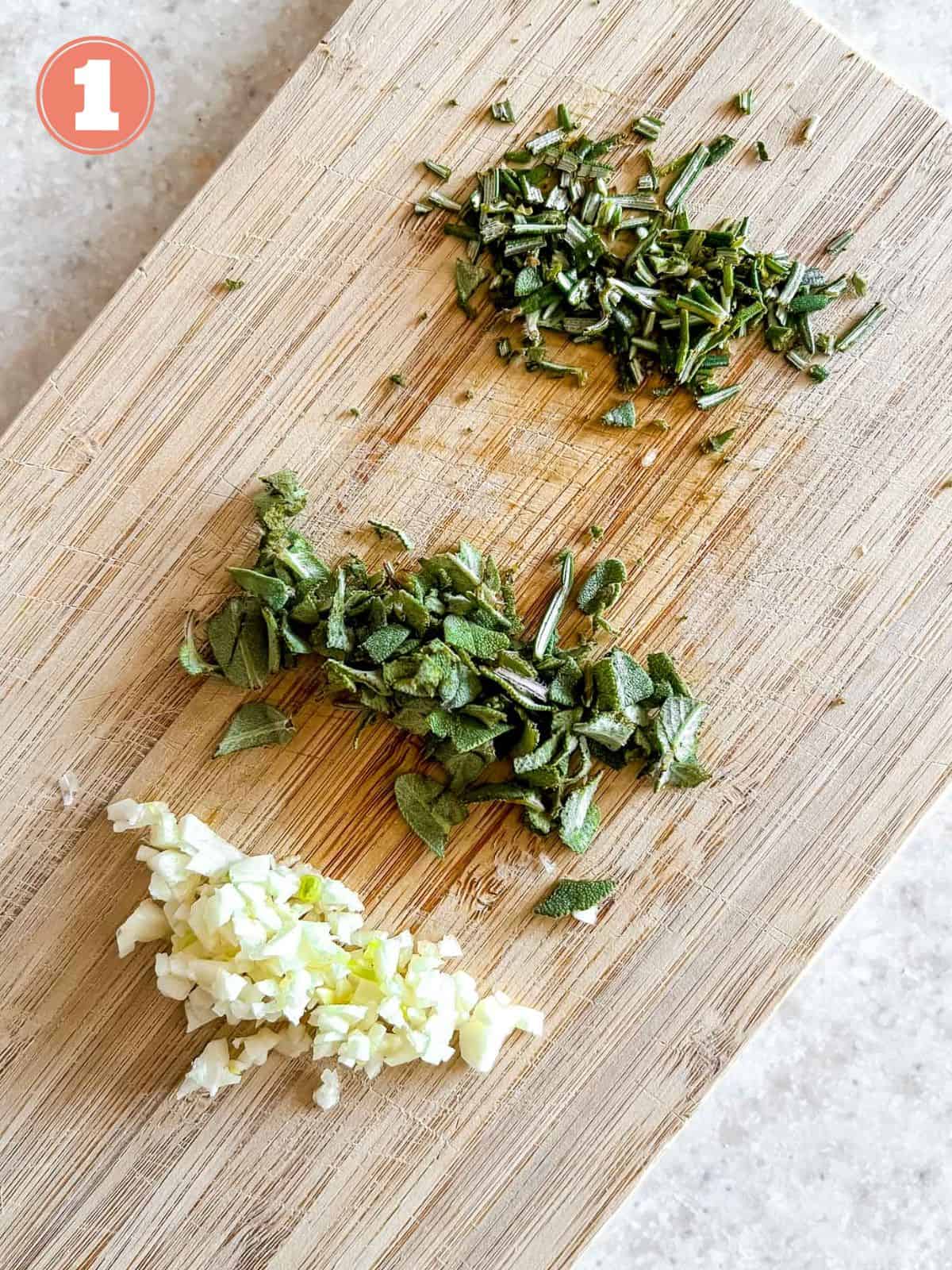 diced herbs and garlic on a wooden board labelled number one.