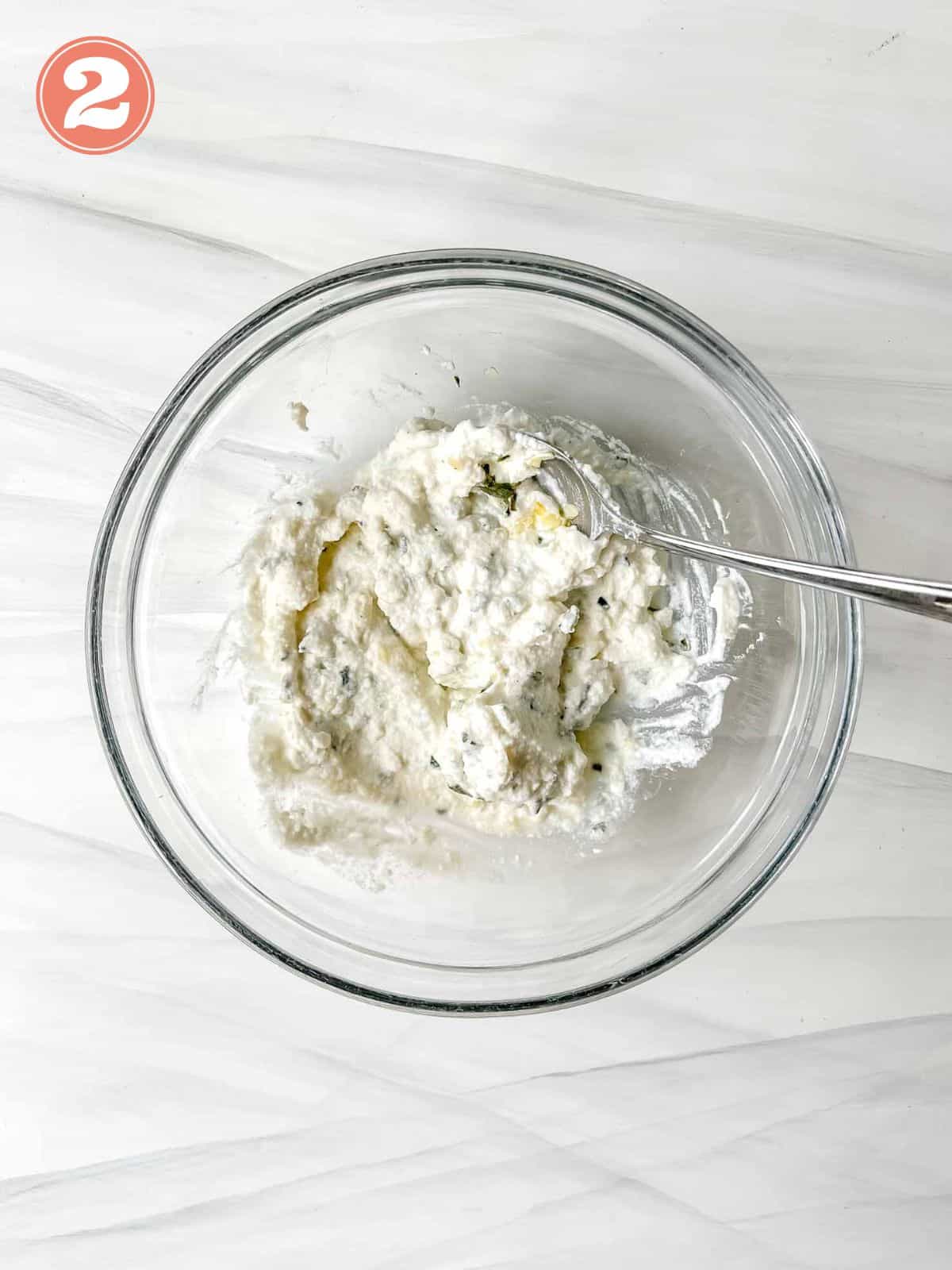 ricotta and herbs mixed in a glass bowl labelled number two.