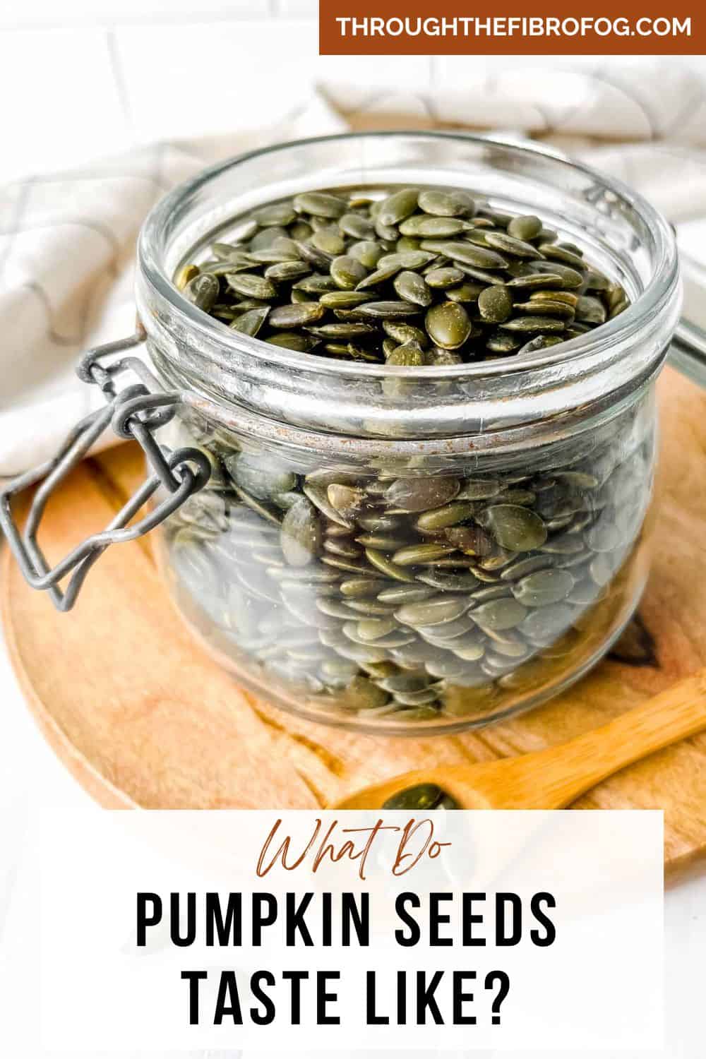 labelled what do pumpkin seeds taste like with a glass jar of pumpkin seeds on a wooden board.