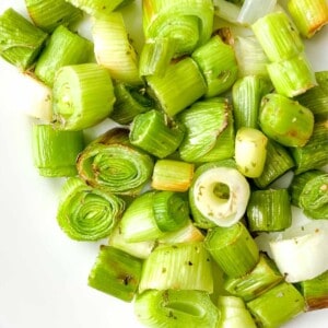 cooked diced leeks on a white plate.