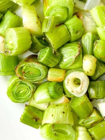 cooked diced leeks on a white plate.