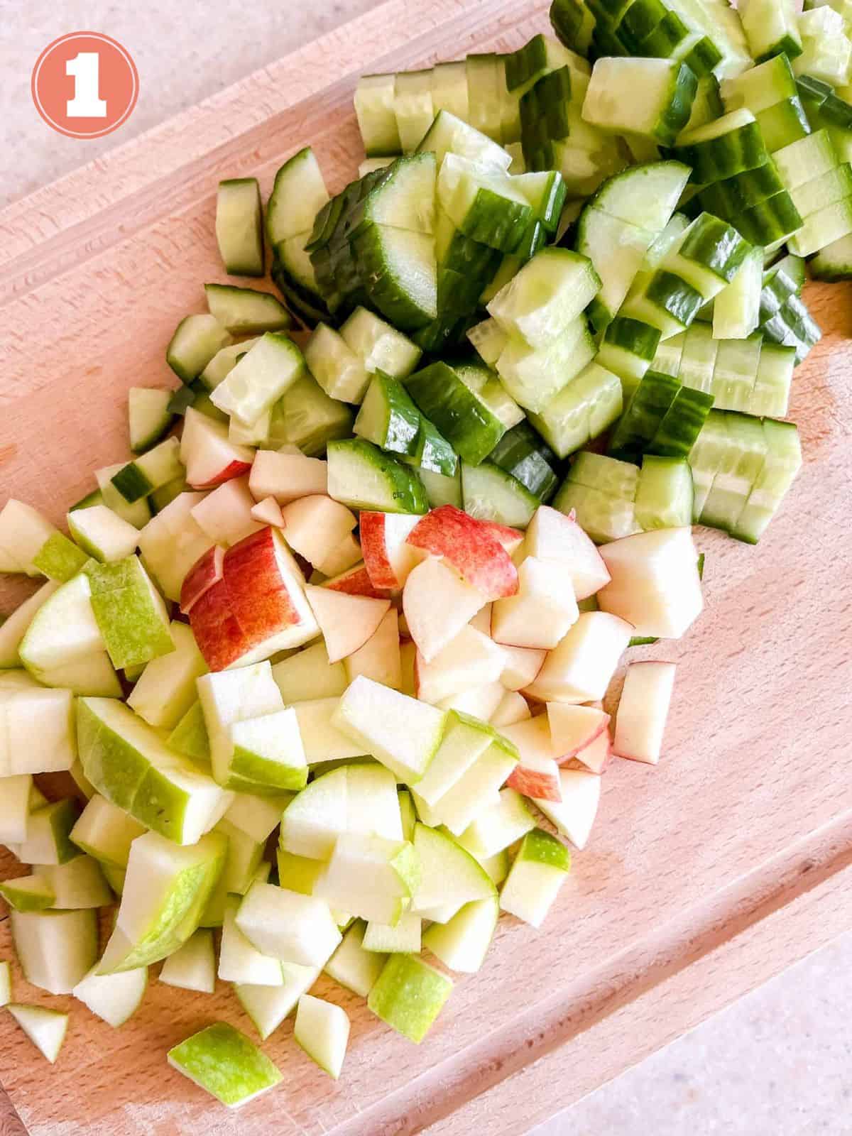 chopped cucumber, red apple and green apple on a chopping board labelled number one.