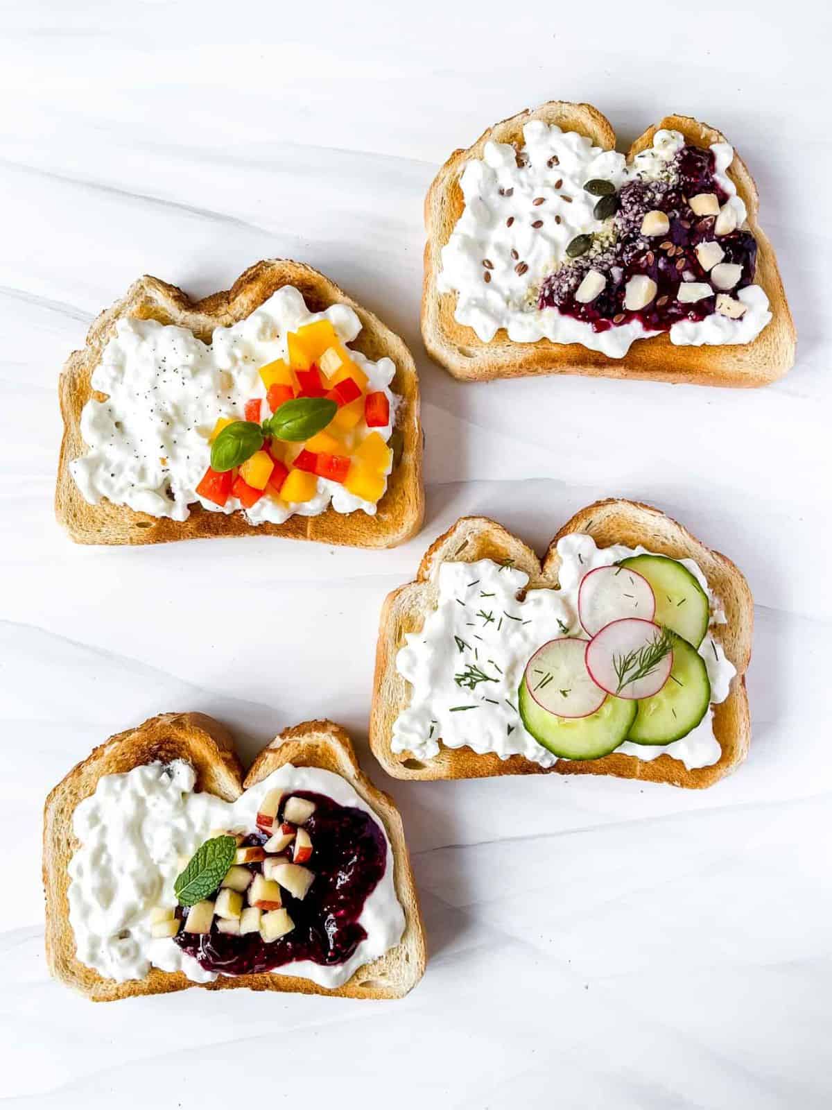 four cottage cheese toasts with a variety of toppings of jam, herbs, vegetables and nuts.