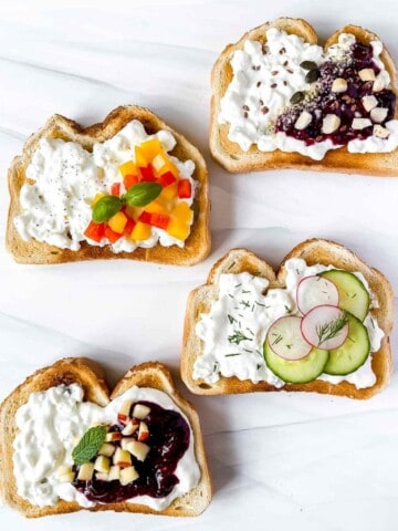 four cottage cheese toasts with a variety of toppings of fruits, jam and vegetables.