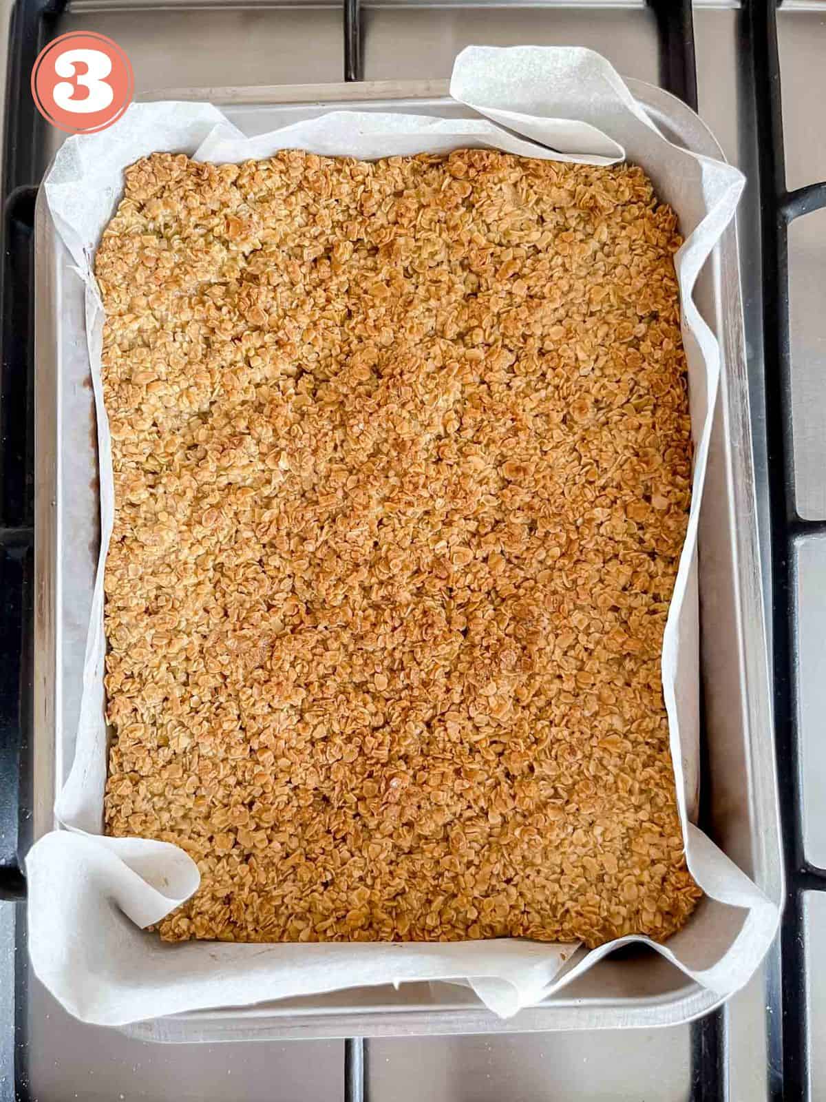 flapjack in a baking tin lined with parchment paper labelled number three.