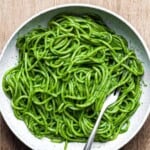 spaghetti with cavolo nero sauce in a light grey bowl with a fork in it.
