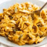 pumpkin pasta sauce recipe in a light grey bowl with a fork in it.