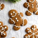 gingerbread men on parchment paper next to green ferns.