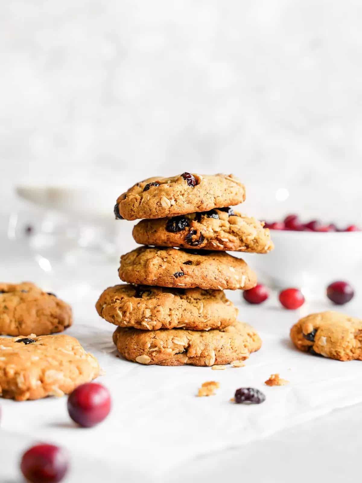 oatmeal cranberry cookies in a stack next to fresh cranberries and cookies.