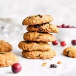 oatmeal cranberry cookies in a stack next to fresh cranberries and cookies.