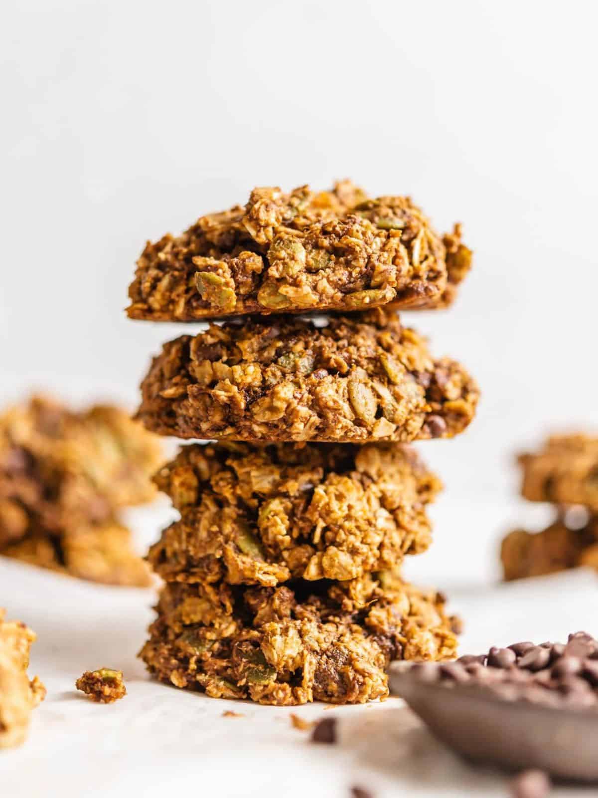 vegan sweet potato cookies in a stack next to a bowl of chocolate chips.
