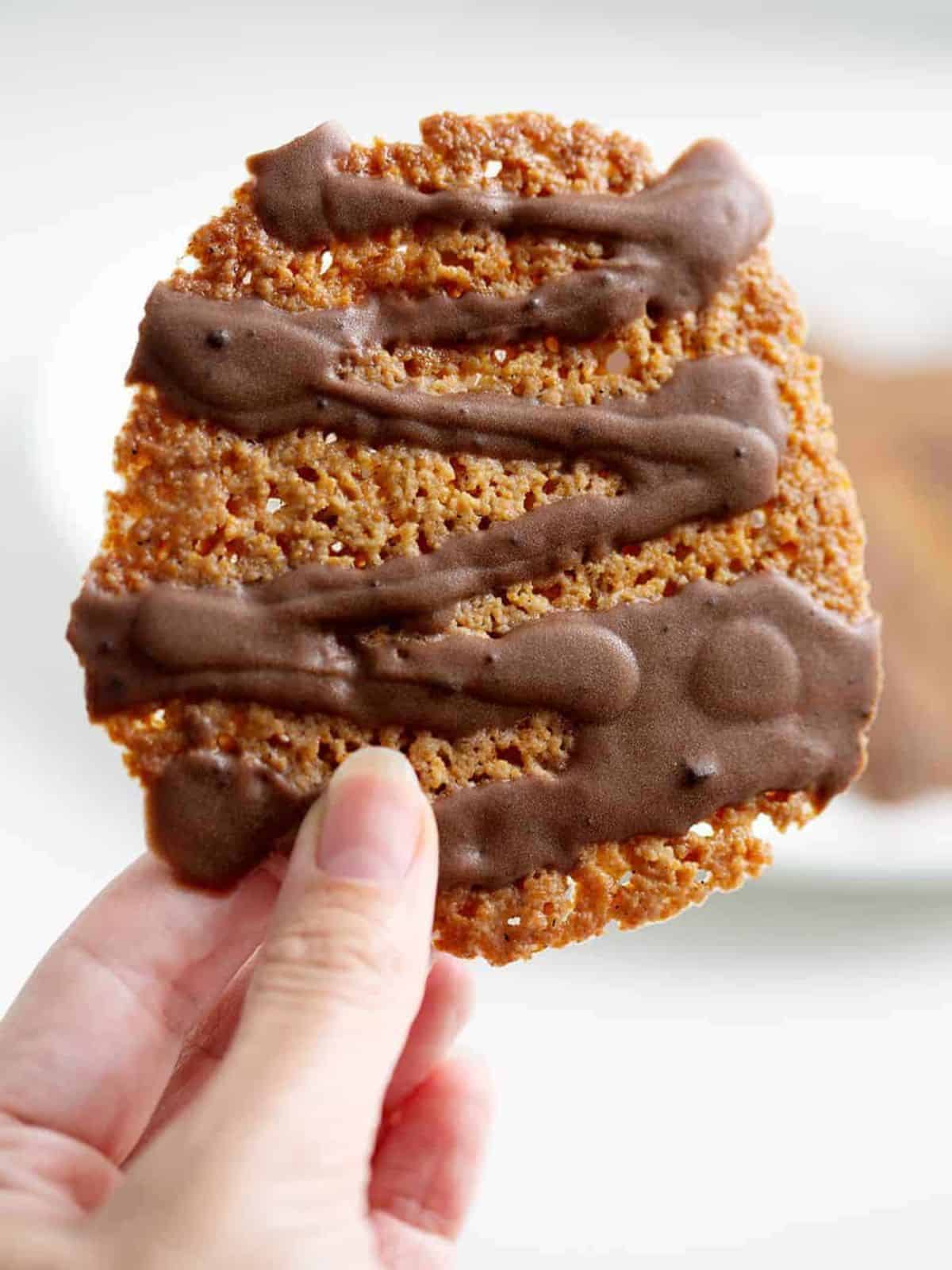 lace with cookie being held in the air.