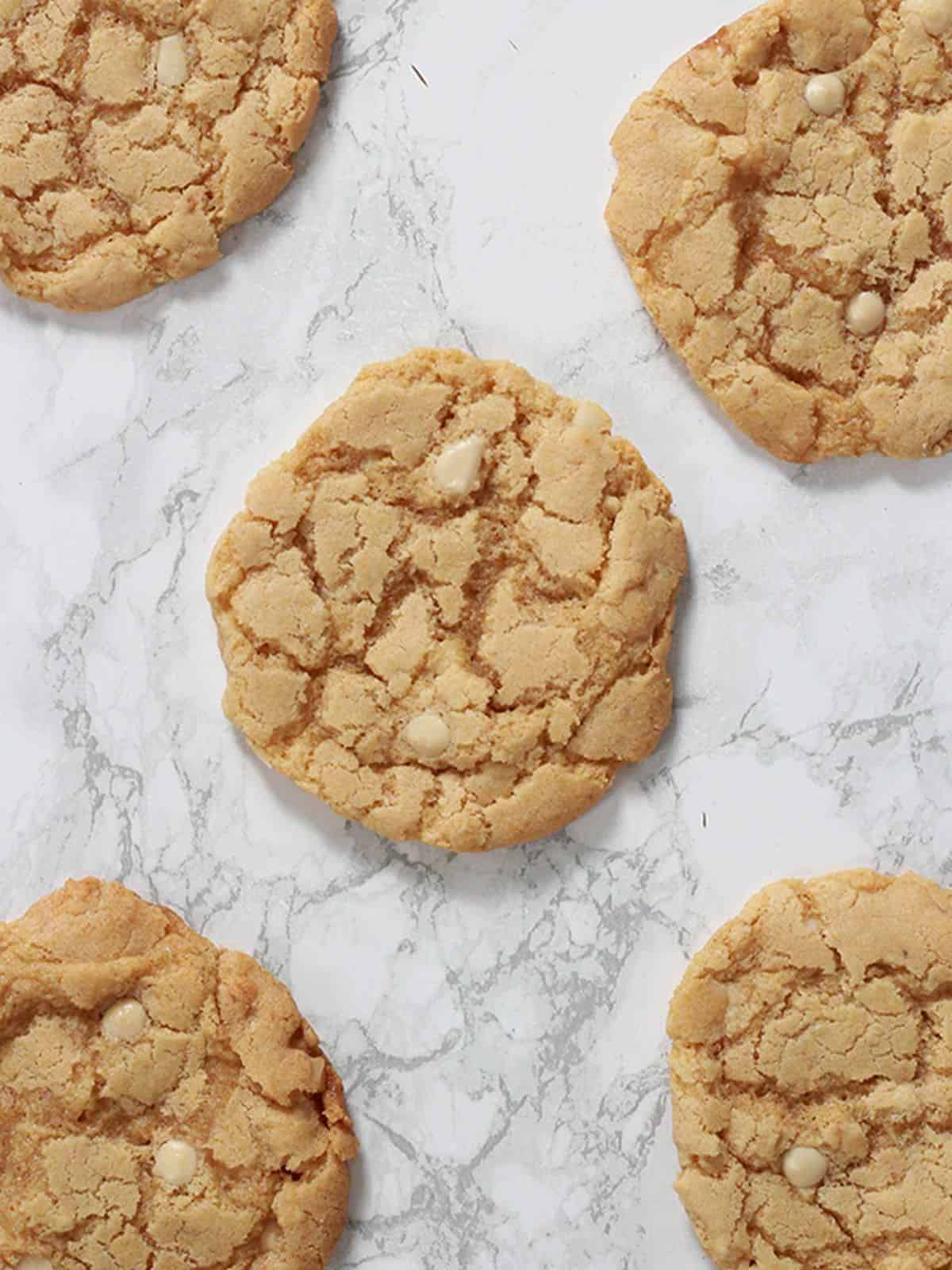 gluten free vegan white chocolate macadamia cookies on a marble background.