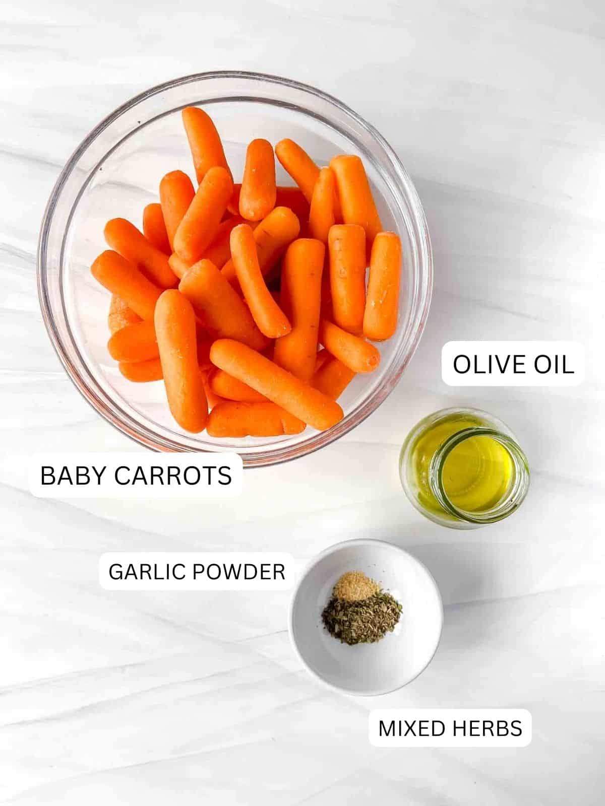 individually labelled bowl of baby carrots, bottle of olive oil and bowl of mixed herbs and garlic powder.
