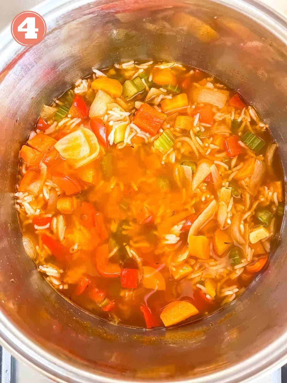 diced vegetables, rice and vegetable stock in a soup pot labelled number four.