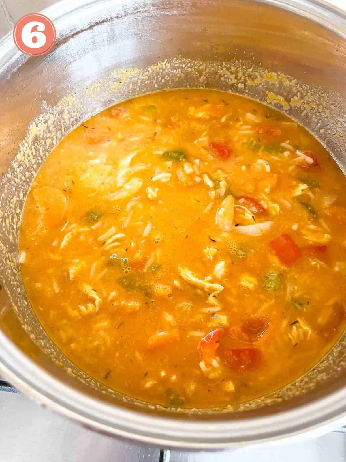 paprika chicken soup in a soup pot in a stove top labelled number six.