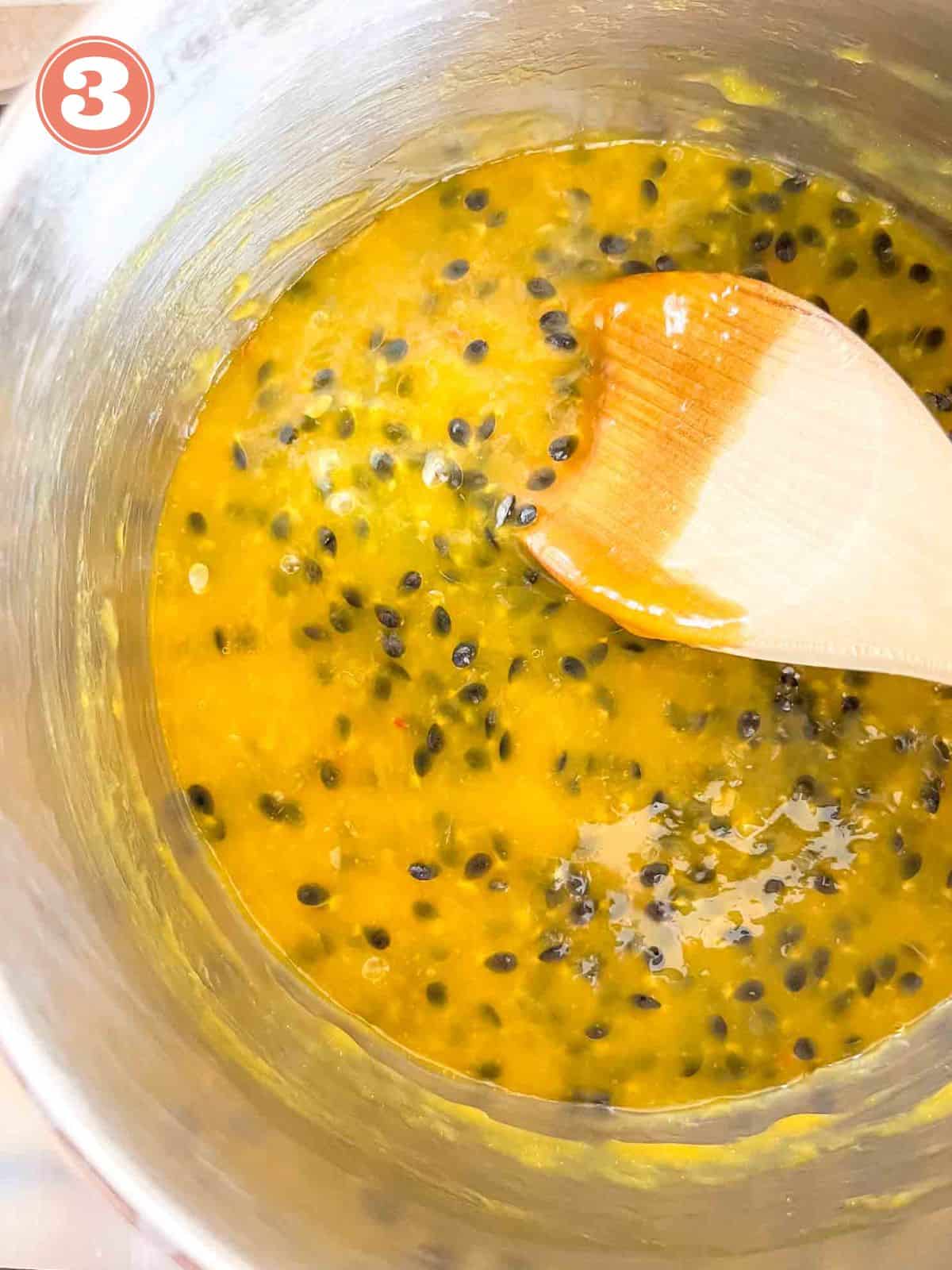 passion fruit coulis being stirred with a wooden spoon in a pot labelled number three.