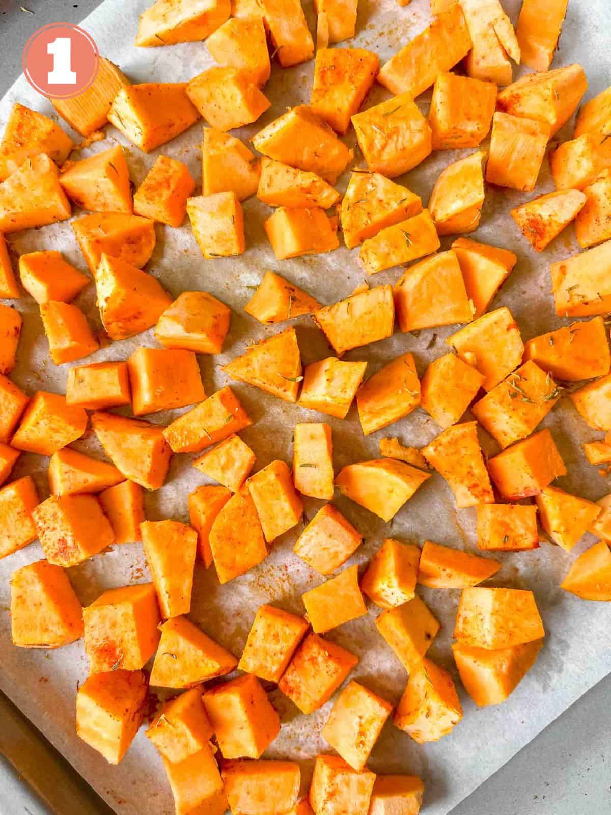 diced sweet potato cubes on a lined baking sheet labelled number one.